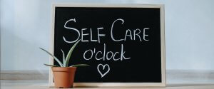 Chalk board with Self Care o'clock written on it