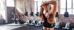 A female university student stretching before starting a gym workout
